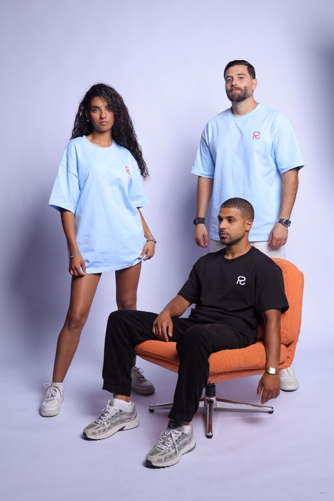Three models in Relentless tees with the red R logo, one seated on an orange chair